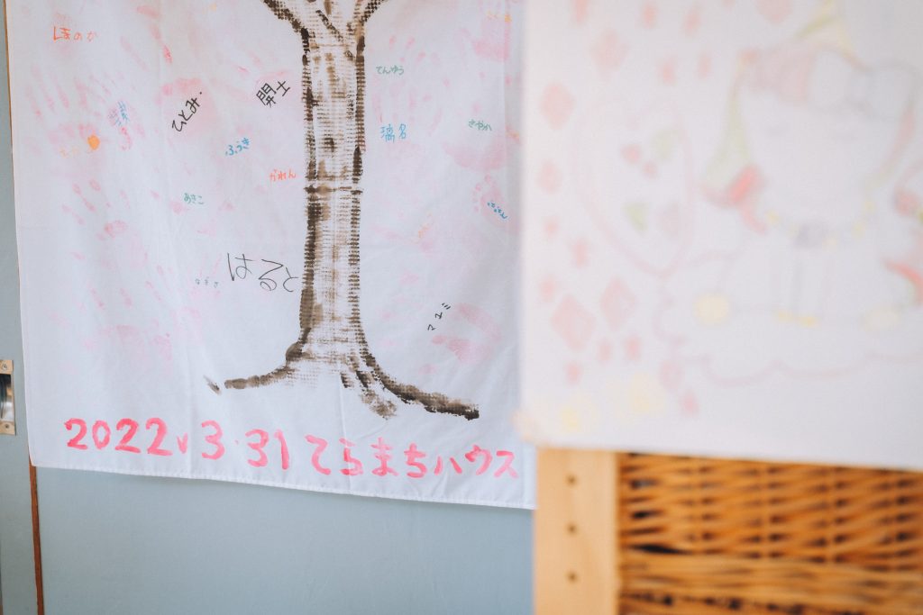 「コミュニティkoen」に飾られる手形タペストリーと子どもの手描きの絵